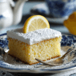 Lemon Crazy Cake slice on plate with lemon garnish