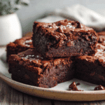 Fudgy chocolate brownies with avocado stacked on a plate