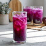 Purple juice recipe in glass with basil garnish