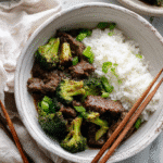 Slow Cooker Beef and Broccoli in a bowl with rice, top-down view