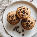 Top-down view of zucchini chocolate chip muffins on a white plate